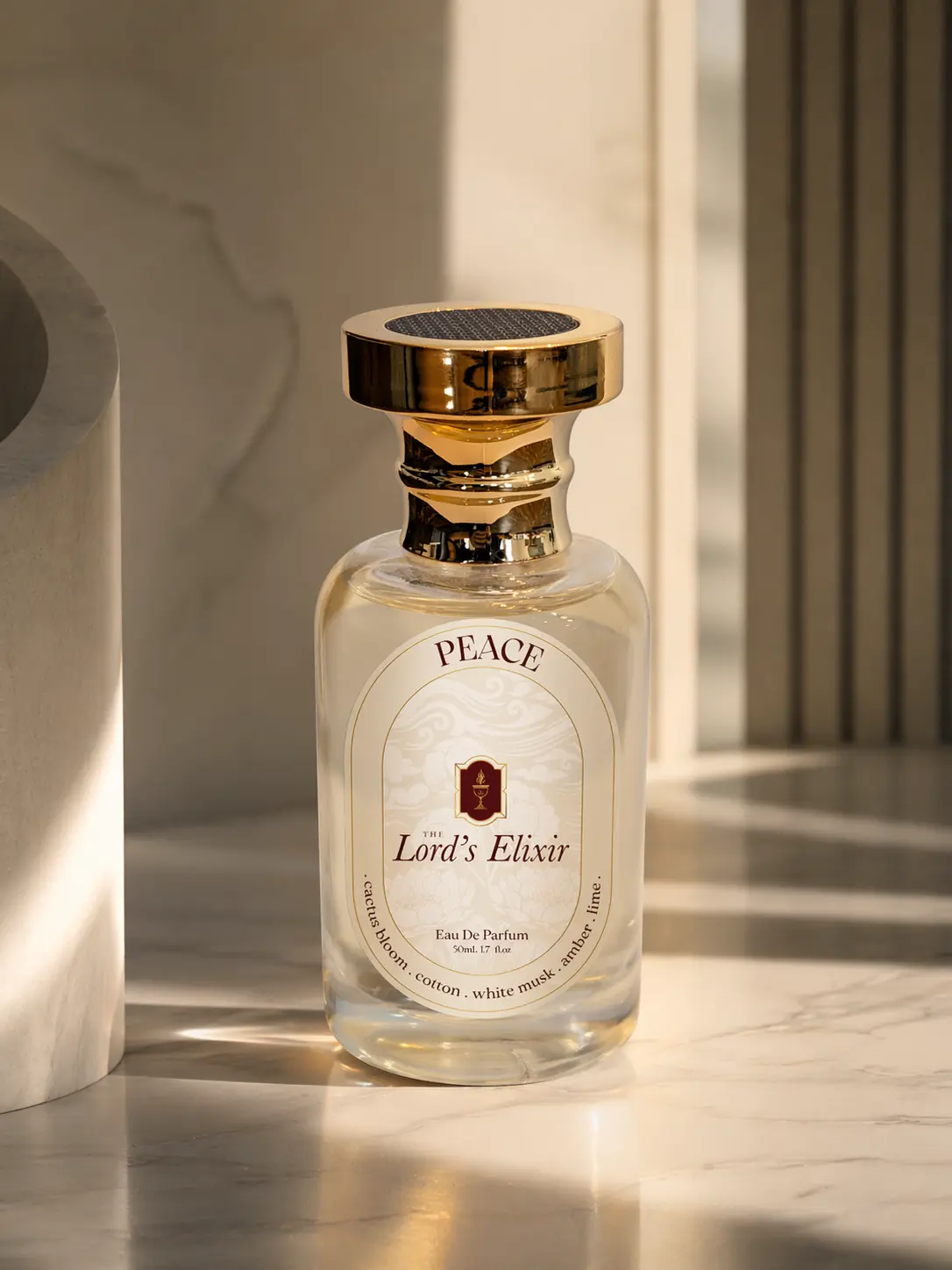 Clear perfume bottle with gold cap on marble
