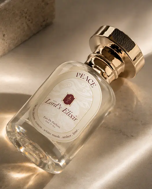 Close-up of Peace Lord's Elixir perfume bottle on beige surface